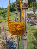 Handmade crochet bow crossbody bag in a beautiful mustard yellow shade. Lightweight, stylish, and perfect for carrying everyday essentials. Crafted with premium quality yarn.