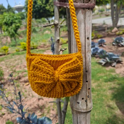 Handmade crochet bow crossbody bag in a beautiful mustard yellow shade. Lightweight, stylish, and perfect for carrying everyday essentials. Crafted with premium quality yarn.